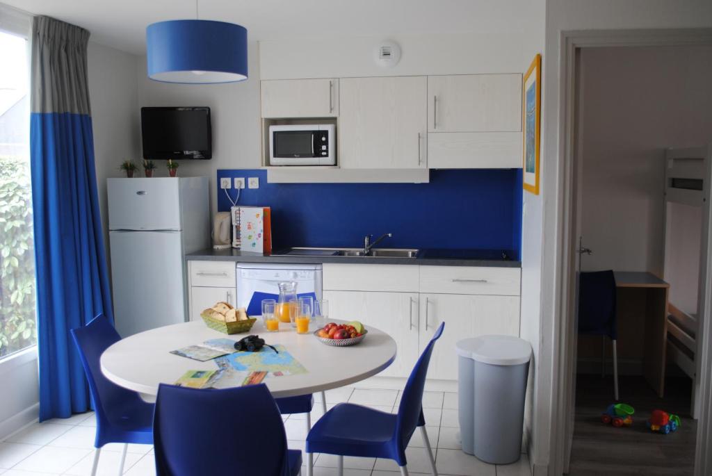 萨尔佐VVF Golfe du Morbihan Sarzeau Arzon的厨房配有桌椅和蓝色的墙壁