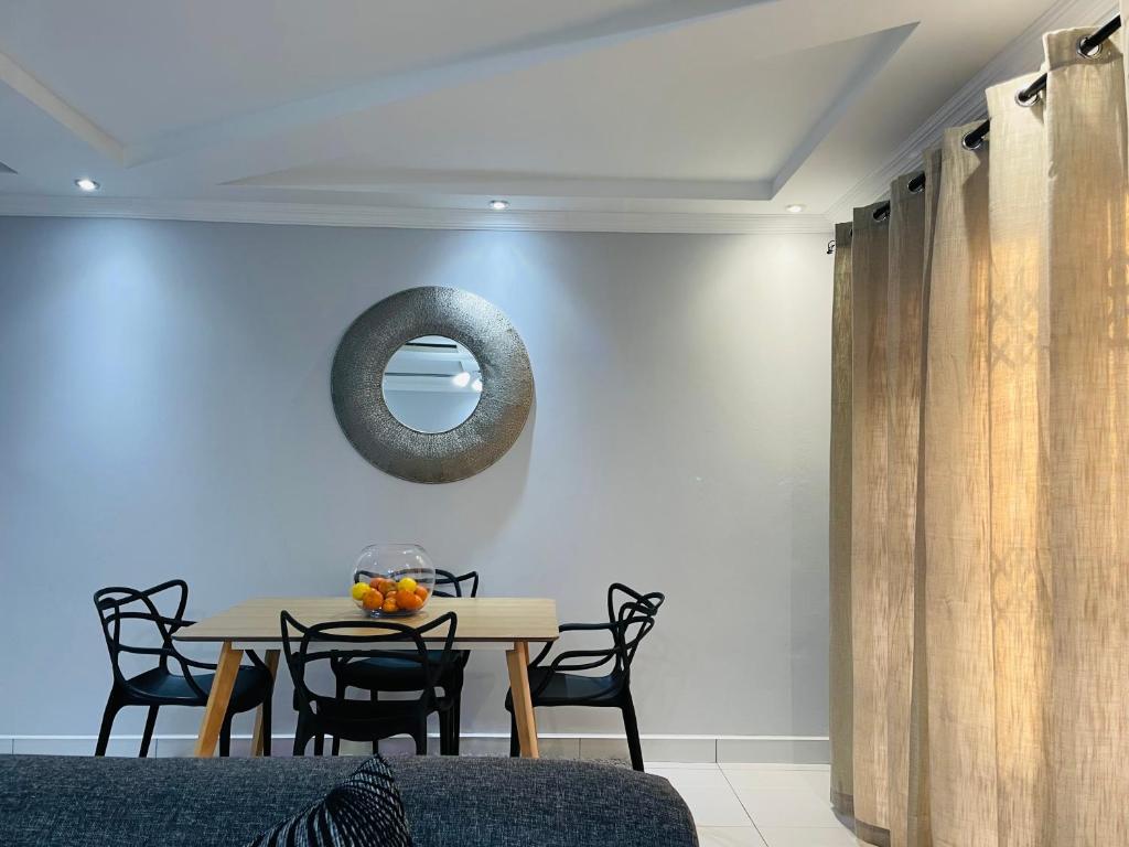 马塞卢Stunning Modern Home in Maseru的一间带桌椅和镜子的用餐室