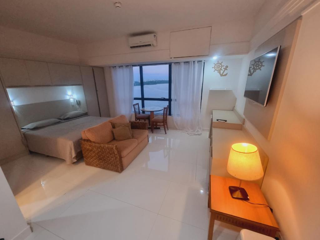 马瑙斯Tropical Executive Vista Ponta Negra的一间卧室配有一张床、一张沙发和一张桌子