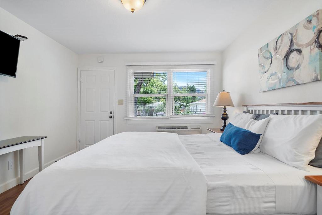 卡利斯托加Carlin's Cottage Court的白色卧室配有白色大床和蓝色枕头