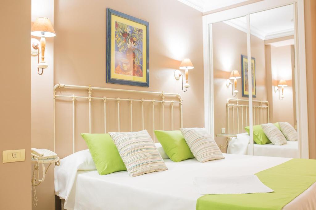 拉克鲁斯RF阿斯托利亚酒店 - 仅限成年人的卧室配有白色床和绿色和白色枕头