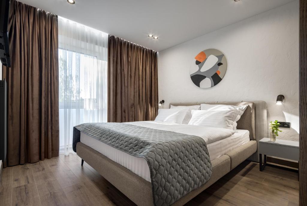 乌日霍罗德Apartel Uzhhorod的一间卧室设有一张大床和一个大窗户