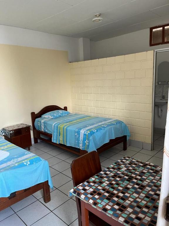 塔拉波托Alojamiento Grau的一间卧室配有两张床和一张桌子及椅子