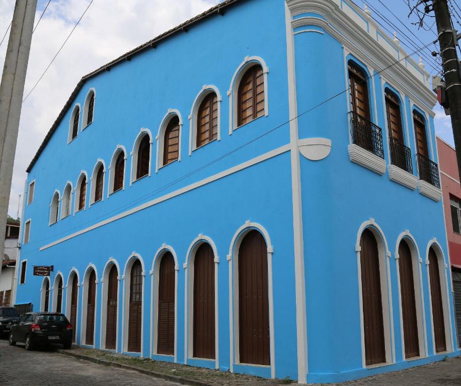 São FélixConforto e bom gosto no Recôncavo da Bahia.的一条蓝色的建筑,在街上有拱形窗户