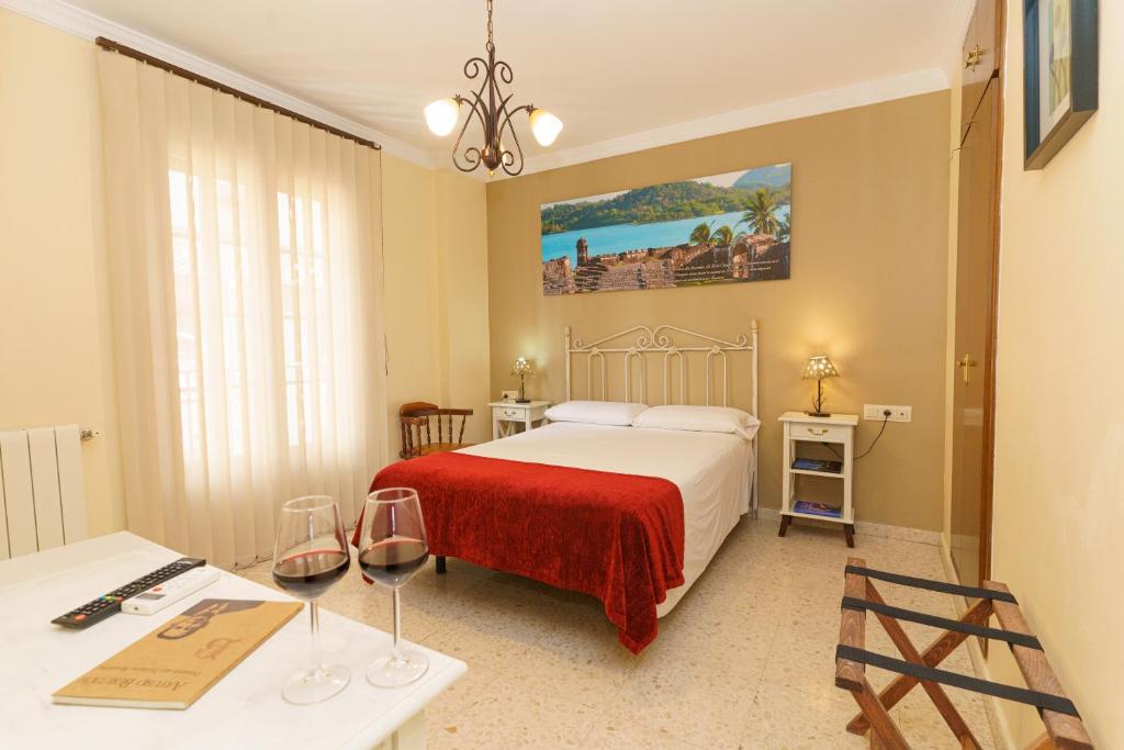 隆达科隆酒店的酒店客房,配有床和桌子,配以酒杯