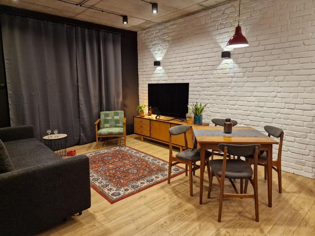 蒂科钦Apartamenty LOFTykocin的客厅配有桌子和电视