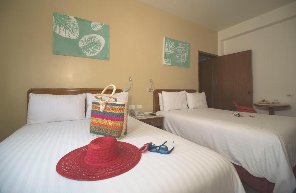 比亚埃尔莫萨Olmeca Plaza Urban Express的两张床上挂着红帽子