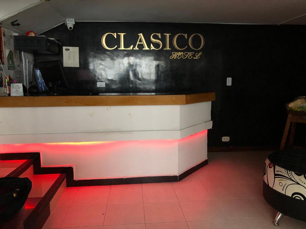 马尼萨莱斯Hotel Clasico的餐厅设有墙上标牌的酒吧