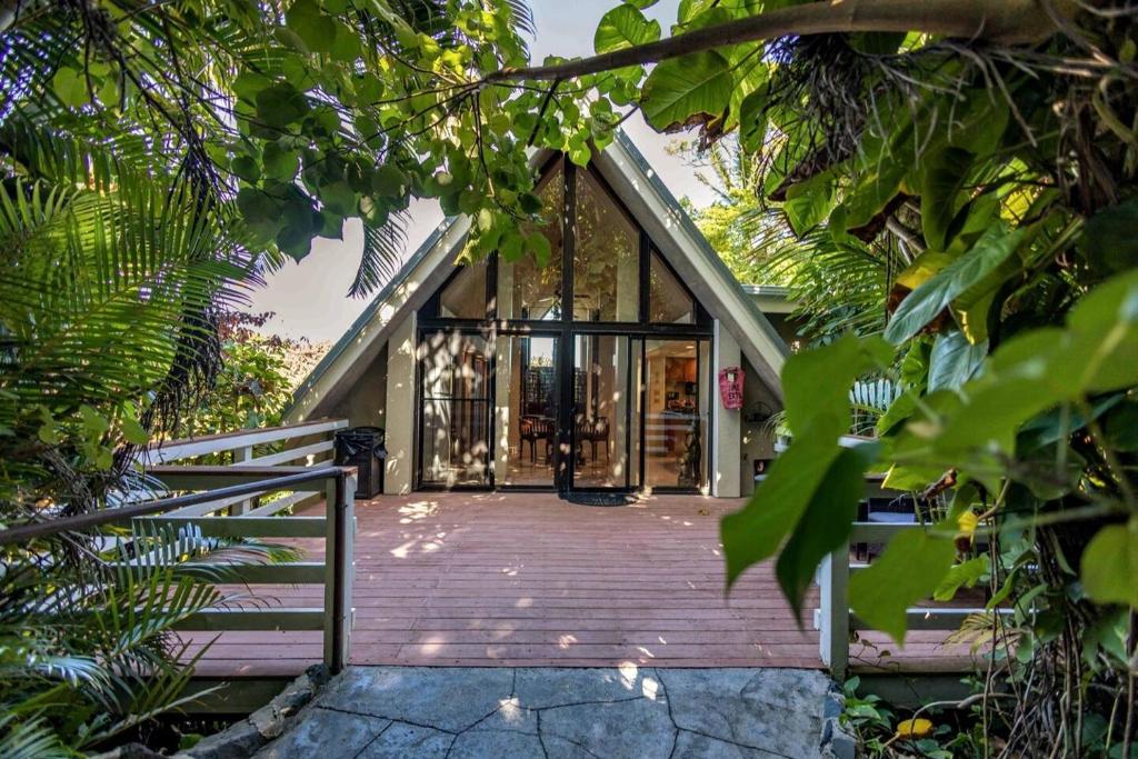 HueloJasmine Suite on Lush farm in Haiku, Maui jungle的通往玻璃门的木道房子