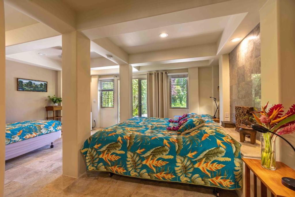 HueloGardenia Room on Tropical Lush Farm in Haiku, Maui的一间卧室配有一张带蓝色棉被的床