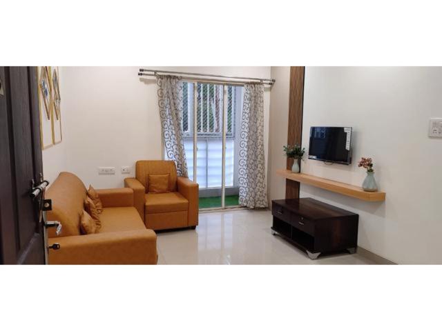 海得拉巴B S Homes的客厅配有两张沙发和一台电视机