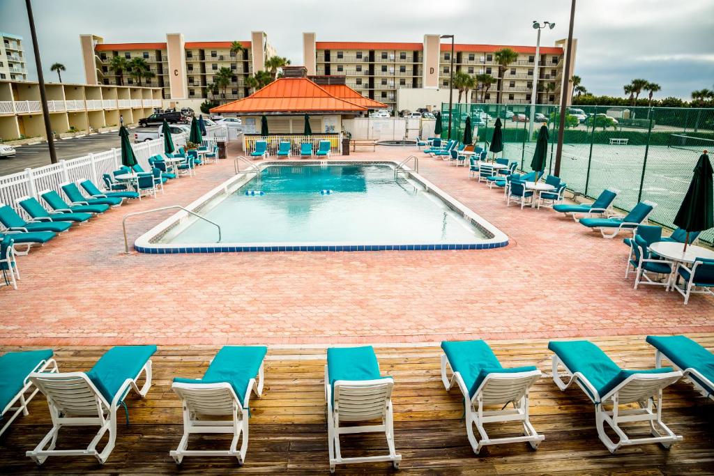可可比奇兰丁斯海洋度假酒店的一座带躺椅的酒店游泳池以及一座建筑