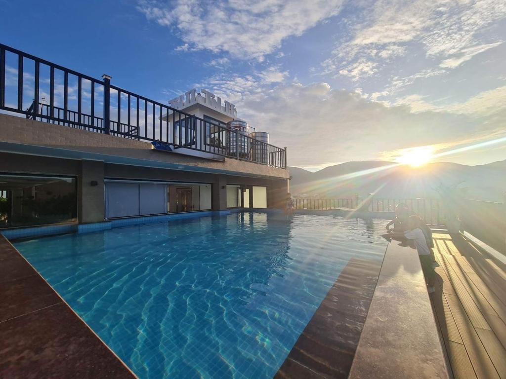 昆岛Tuấn Ninh Hotel II的一座带阳光的建筑的顶部游泳池