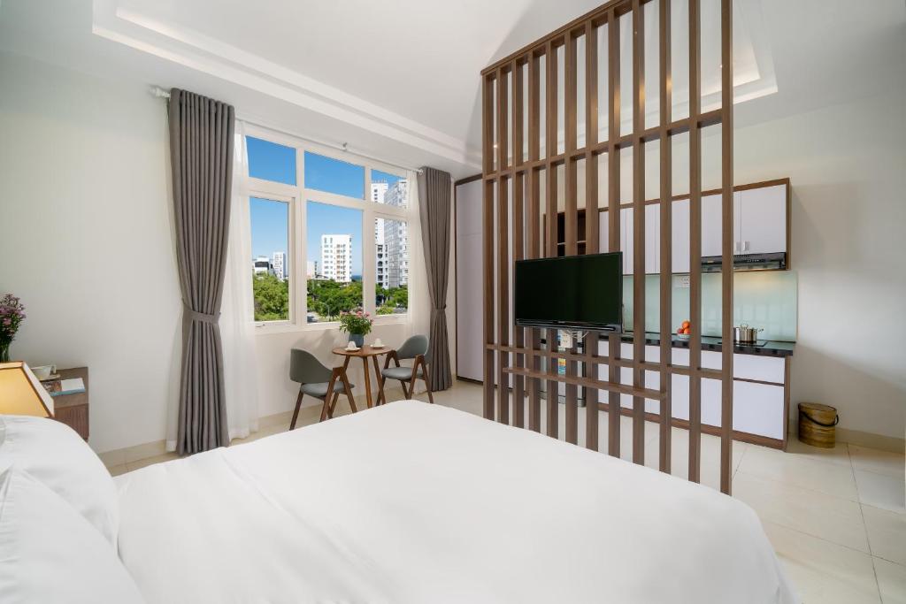 岘港Tashi Park View Hotel & Apartment的一间卧室配有一张床和一台平面电视