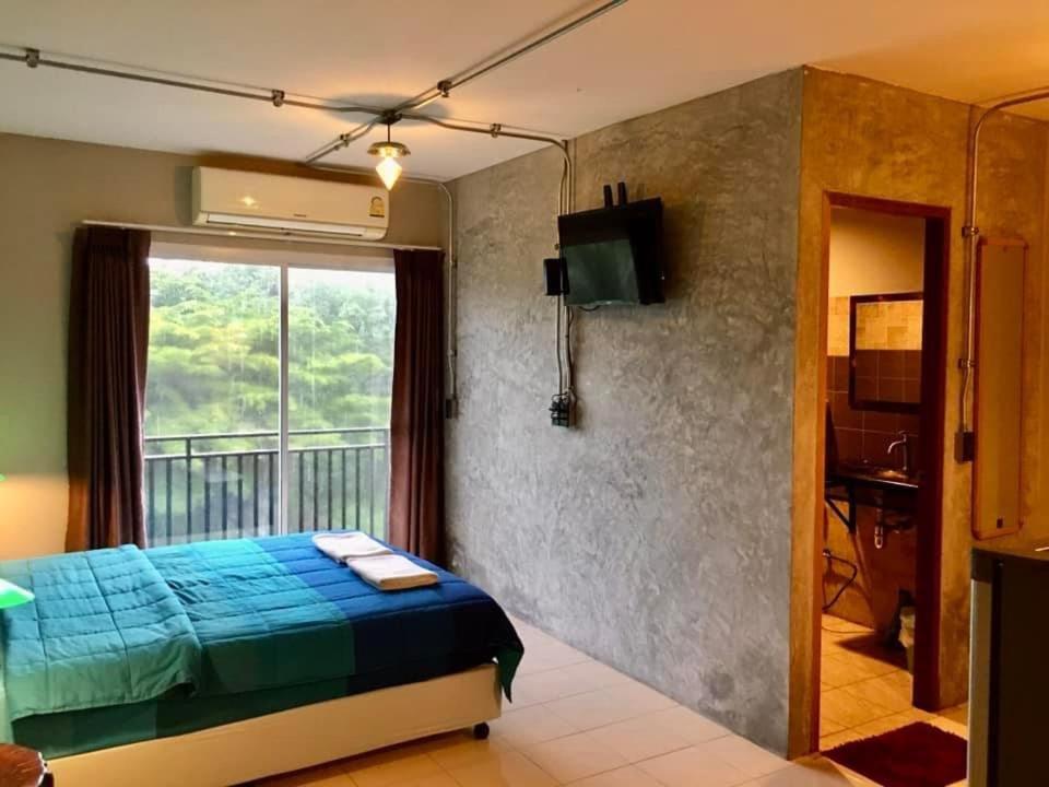 蔻立khaolak big bike&room for rent的一间卧室设有蓝色的床和一个阳台