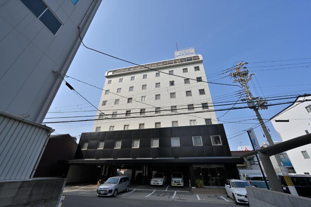 和歌山和歌山县第一核电站富士酒店的一座高大的白色建筑,汽车停在停车场