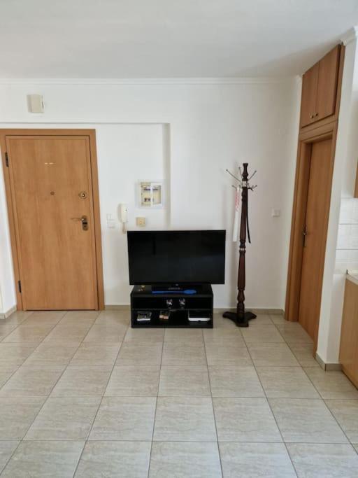 尼亚·蒙达尼亚Πλήρως εξοπλισμένο διαμέρισμα.的客厅配有平面电视和三角架