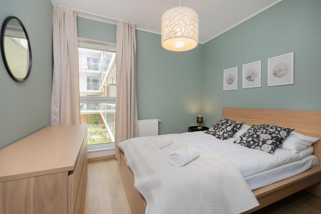 格但斯克Bright & Stylish Apartment with Balcony 1,5 km to Gdańsk Main City by Renters的一间卧室配有一张带镜子的床和窗户