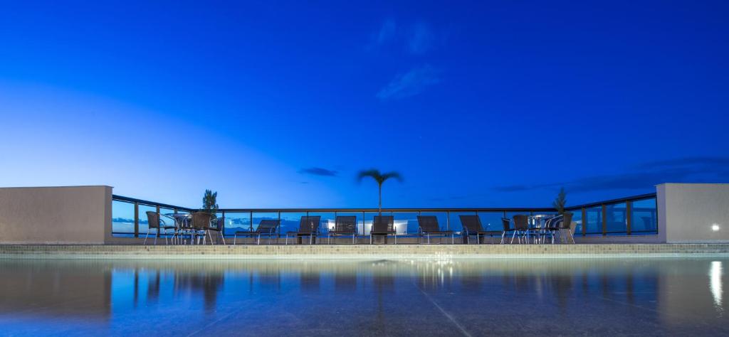 伊塔博拉伊伊塔博拉伊长廊尊贵公寓式酒店的夜晚的游泳池,灯光蓝色