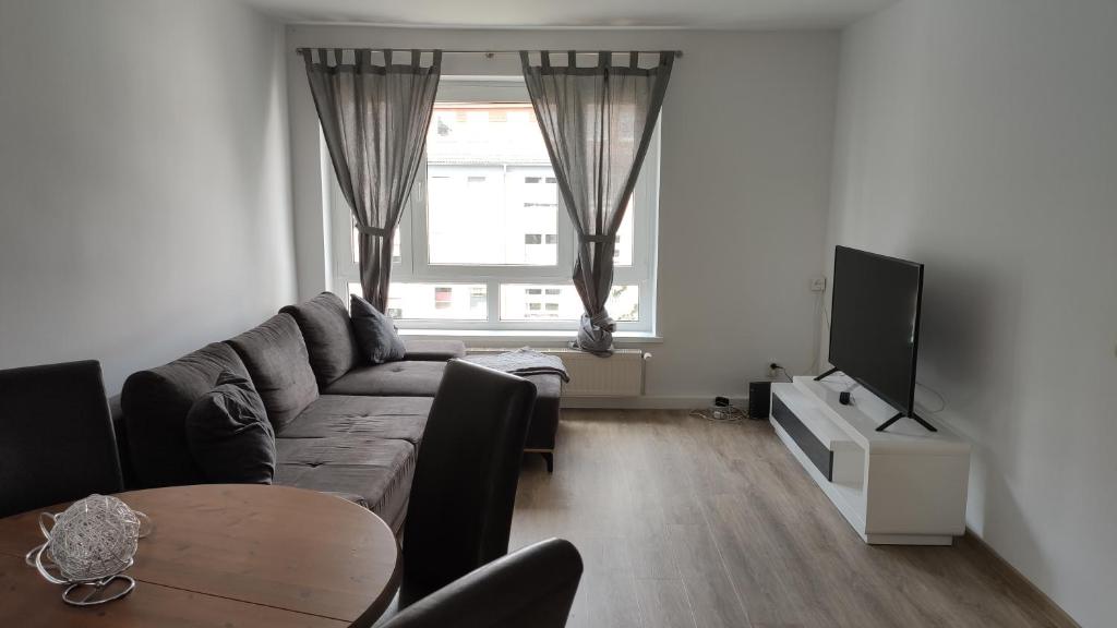 罗斯托克Wohnung Meeresbrise 48 qm mit Balkon的带沙发、电视和桌子的客厅