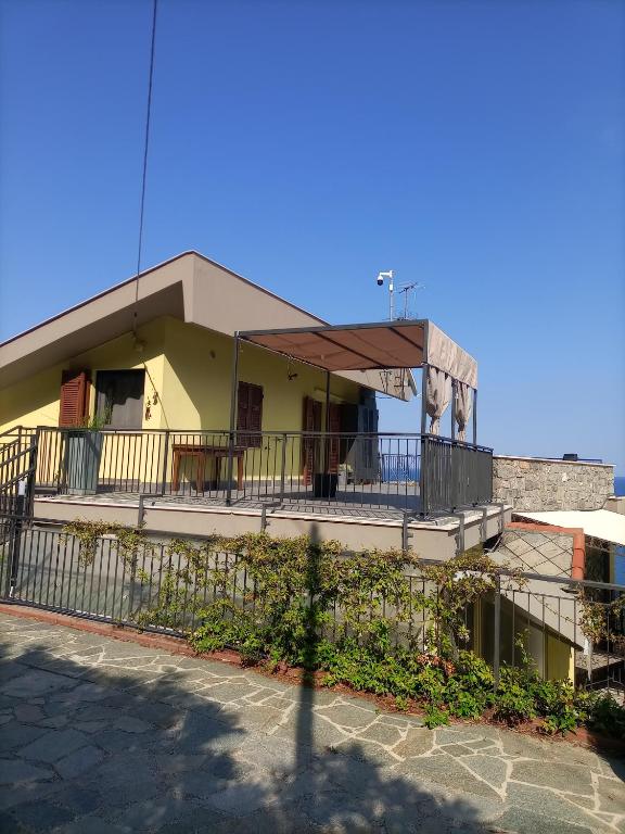 阿拉西奥Mansarda sul mare的带阳台和围栏的黄色建筑