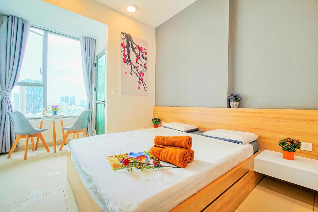 胡志明市INNSiDE Apartment - RiverGate Residence, Free GYM and POOL的一间卧室配有带橙色毛巾的床