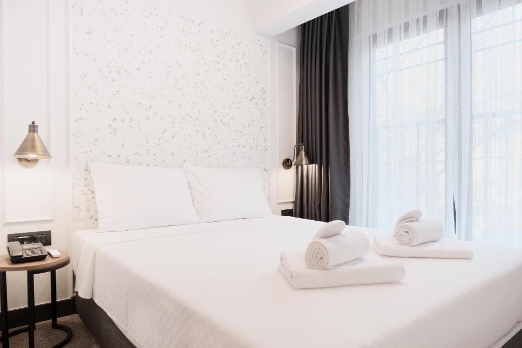 伊斯坦布尔Persona Hotel Galata的卧室配有带毛巾的大型白色床