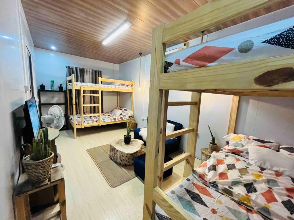 丹辘Kaha Briones Family Guest House的一间带两张双层床的卧室和一间客厅