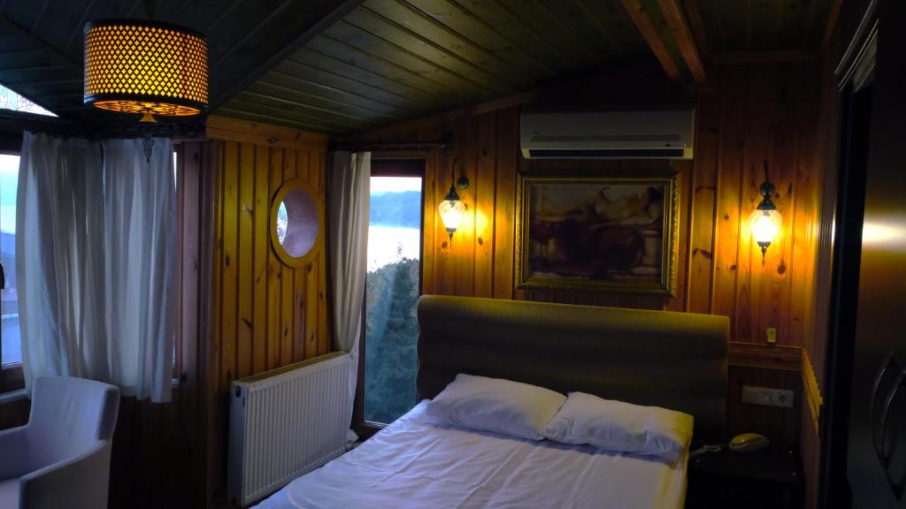 锡诺普丹尼斯酒店的一间小卧室,配有床和窗户