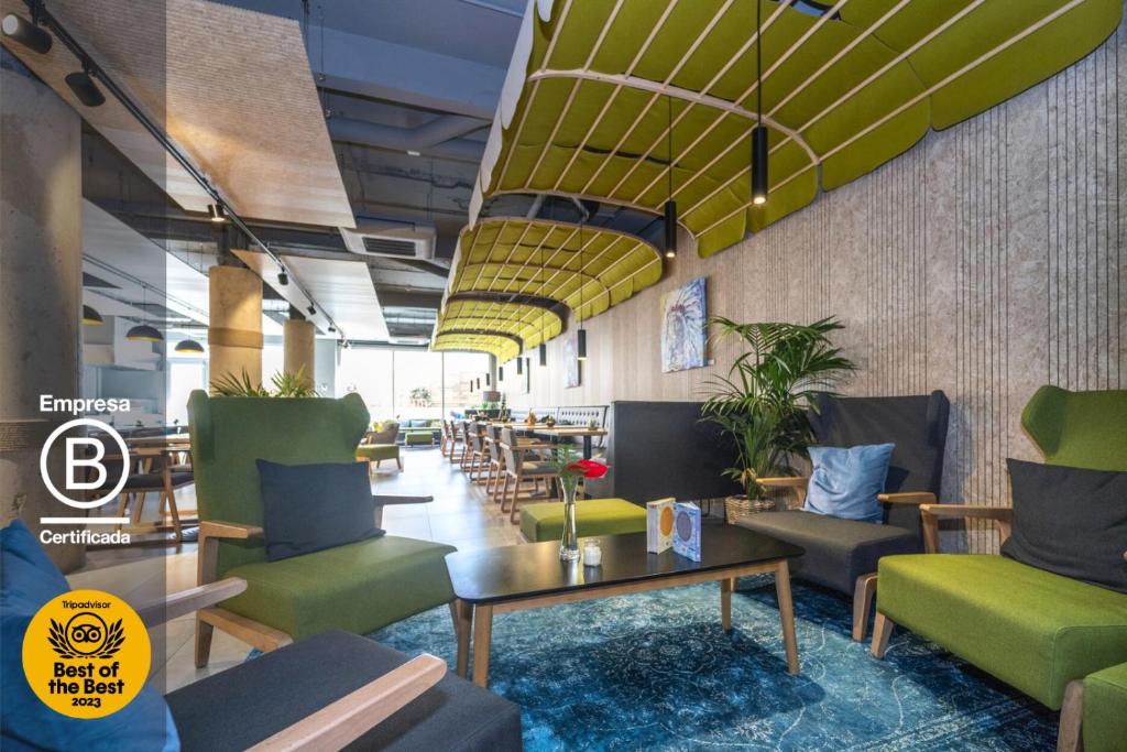 马德里ARTIEM Madrid的餐厅里设有绿椅和桌子的大堂