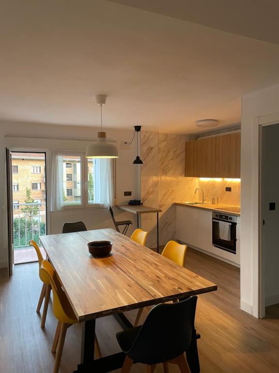 乌苏尔维尔Cozy apartment 6' from San Sebastian + Parking的厨房以及带木桌和椅子的用餐室。