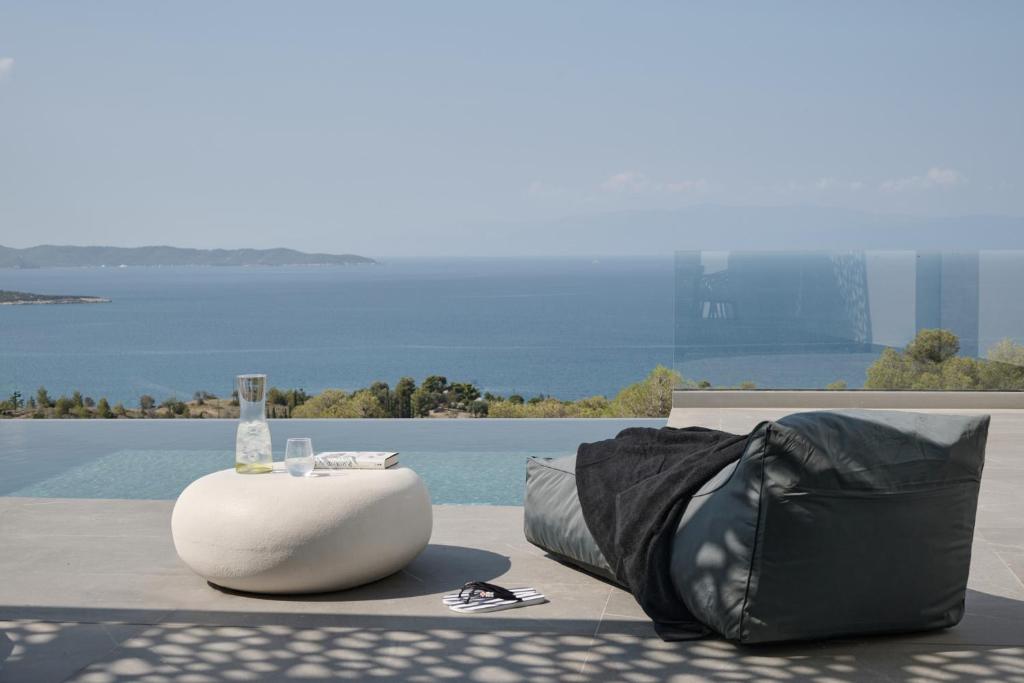 波多河丽Olvos Luxury Villas Porto Heli的袋子和桌子,地面上喝着一杯