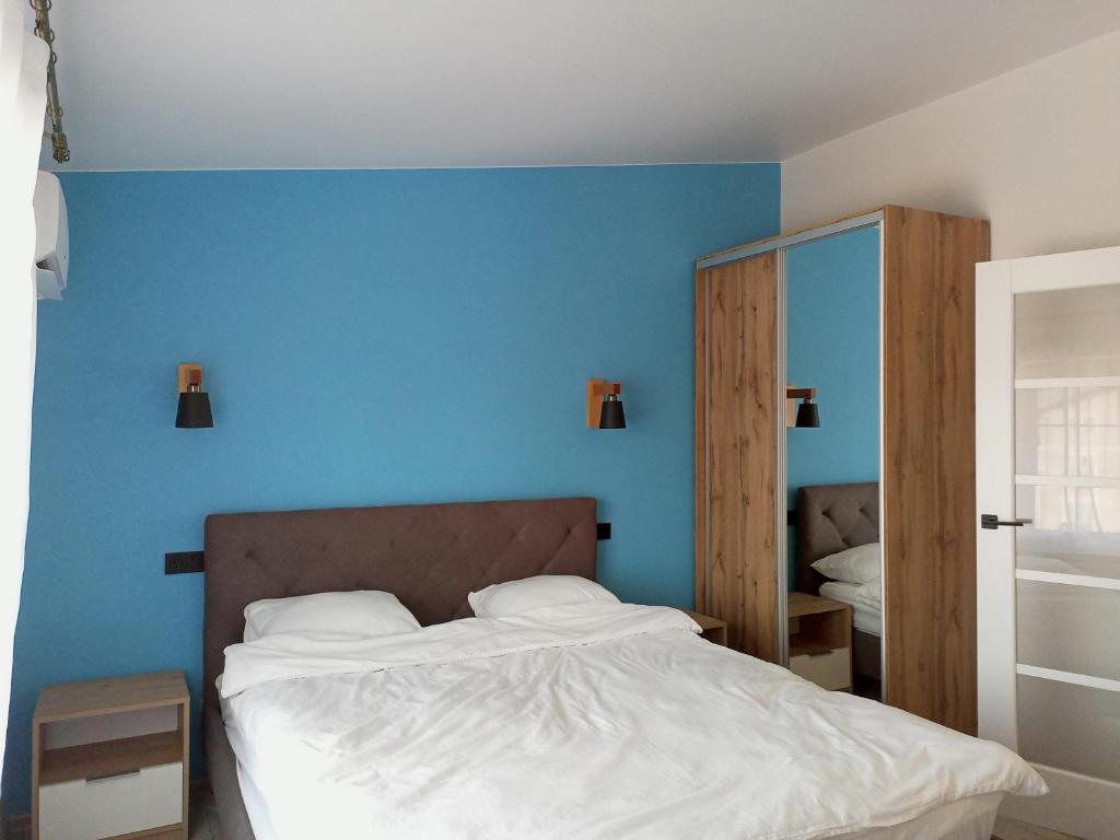 乌日霍罗德Apartment in Bozdosh estate的一间卧室配有一张蓝色墙壁的床