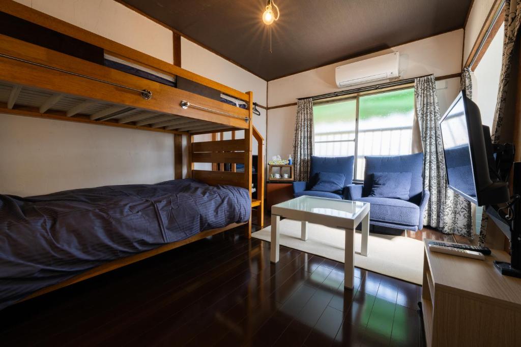 尾道市Bed&Cafe Onzo オンゾー的一间卧室配有双层床和书桌