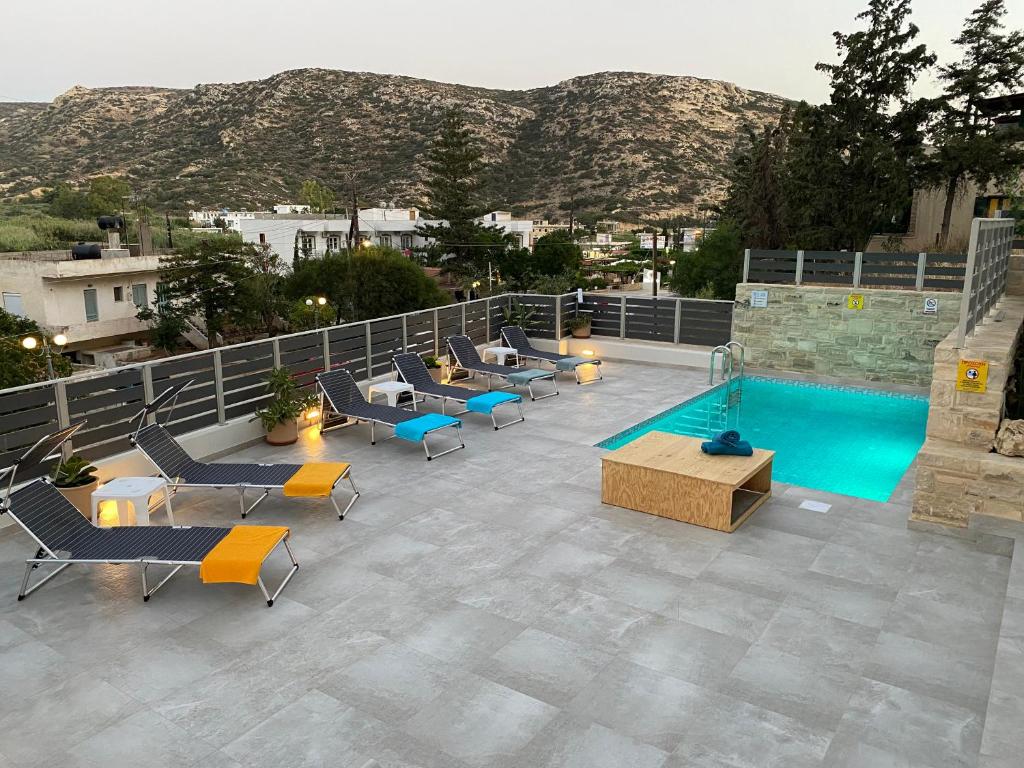 马塔拉Maistro Suites with pool, Matala的一个带椅子的户外庭院和一个游泳池