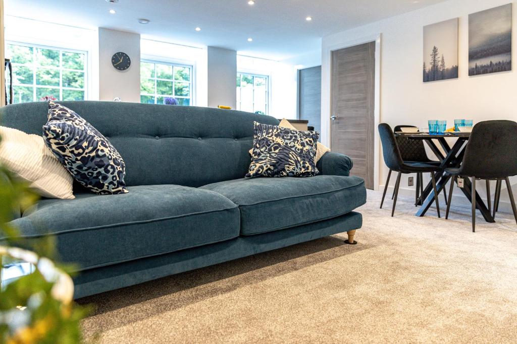 沃克索普Stylish & Contemporary 2-Bedroom House的客厅配有一张蓝色的沙发,配有一张桌子