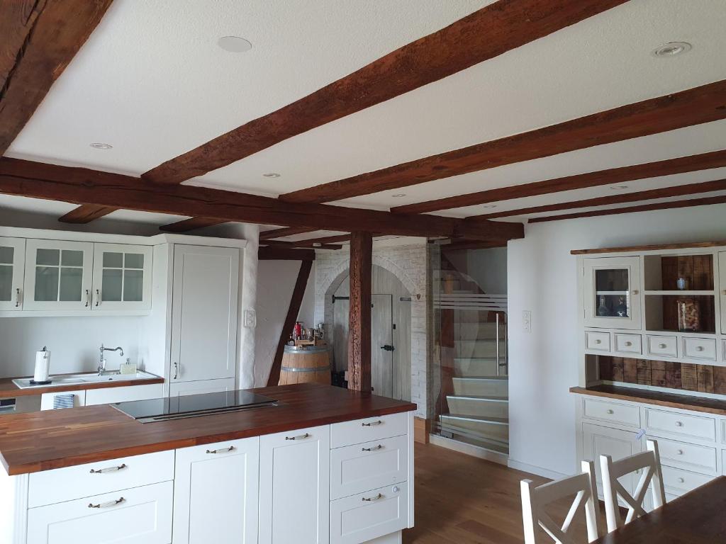 Oberglatt3 Bedroom Swiss House on 3 Floors的厨房配有白色橱柜和木制天花板。