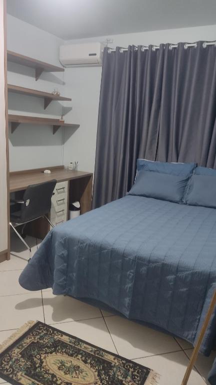 沙佩科Aconchego的一间卧室配有蓝色的床和一张书桌