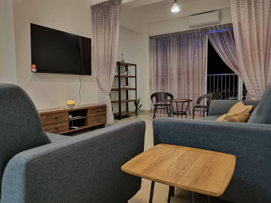 斯里曼绒Manjung CY Homey Stays The Venus Residence的客厅配有2张蓝色沙发和电视