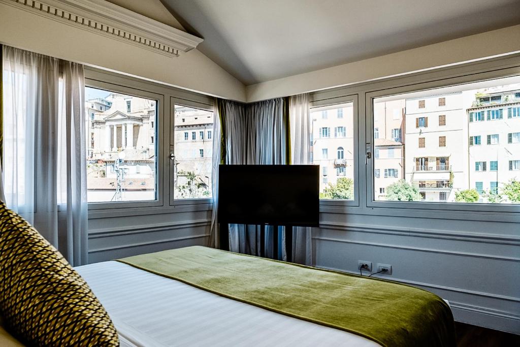 安科纳帕里斯格兰德酒店的一间卧室设有一张配有电视的床和两个窗户。