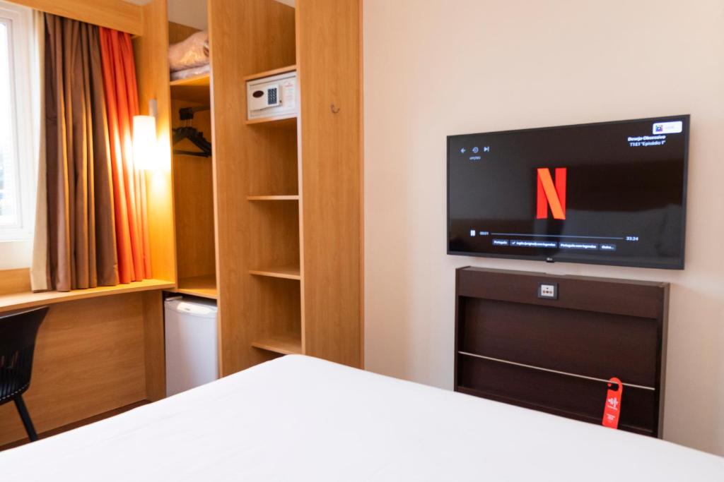 阿雷格里港宜必思博尔特阿尔格雷温托酒店的一间带电视和一张床的卧室