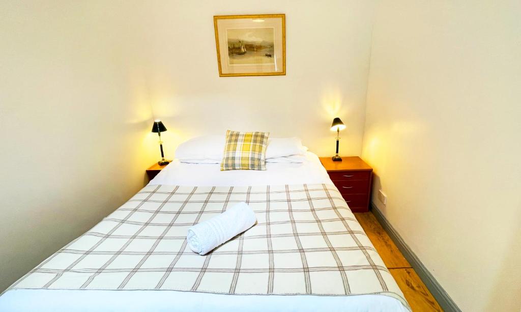 柯克纽顿Pentland Farm Cottage Annex的一张床位,房间设有两个床头柜和两盏灯