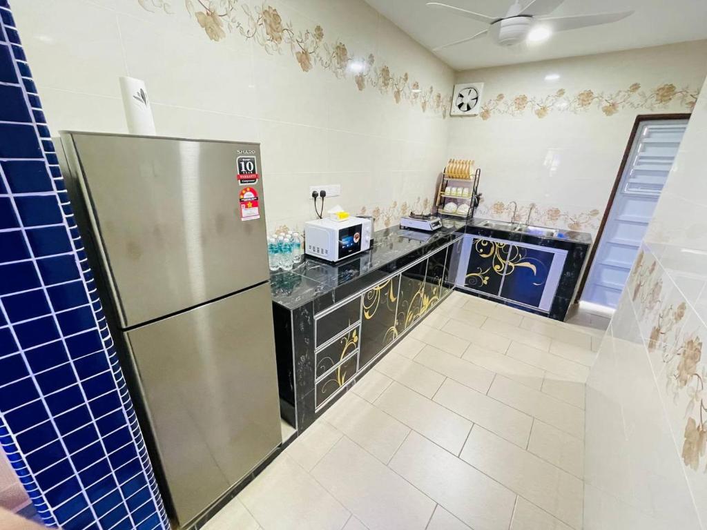 古来Cozy Kulai Retreat 5Min AeonPalm Resort15Min Senai airport的厨房配有冰箱和台面