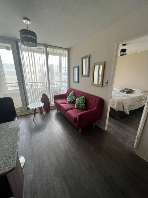 塔尔卡瓦诺Acogedor departamento的客厅配有红色的沙发和床。