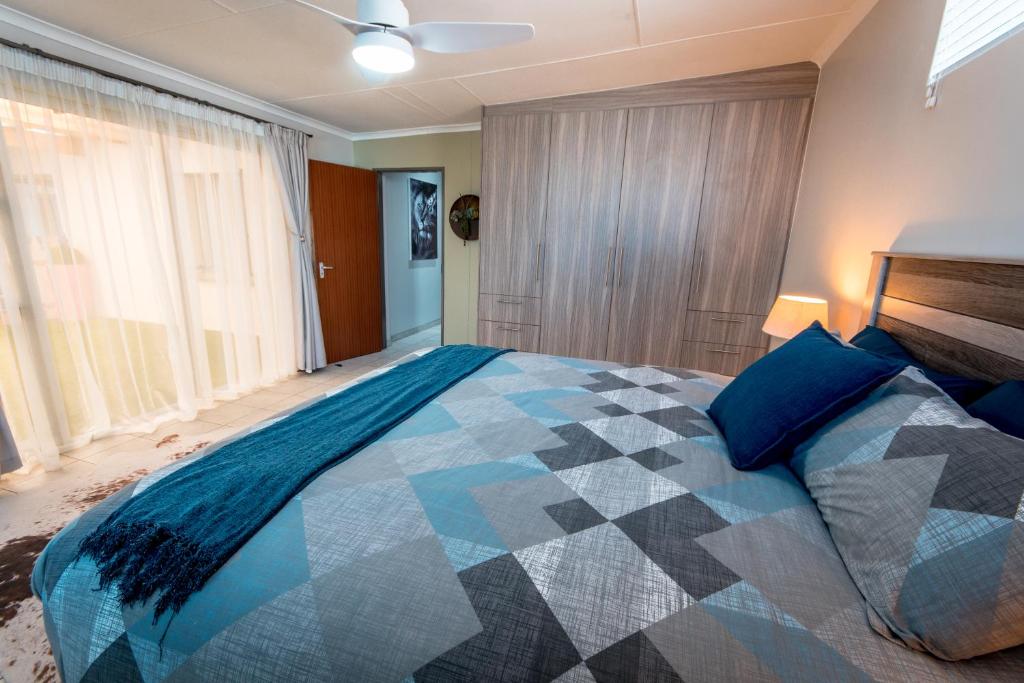 温特和克Meerkat Manor Self-Catering & Accommodation Windhoek的一间卧室配有一张带蓝色枕头的大床