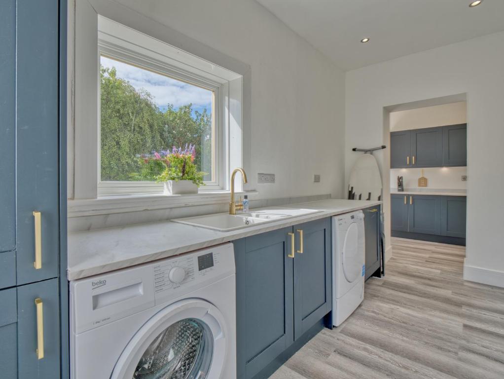 西基尔布赖德Seamill Cottage的厨房配有洗衣机和窗户。