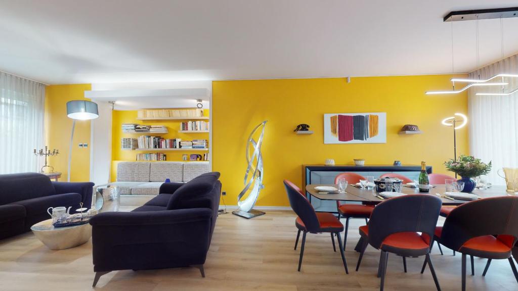 科尔马Maison Mandarine Colmar 5 bedrooms 180m2的客厅设有黄色的墙壁和桌椅