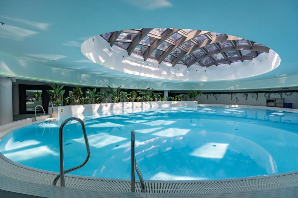 什切青Kaleo apartments - Hanza Tower的一座带天花板的大型游泳池