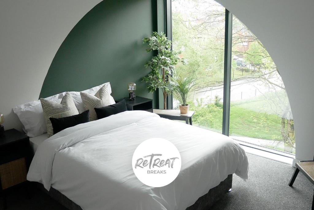 利兹ReTreat Breaks - 3 Bedroom Penthouse - Holbeck Leeds的卧室配有白色的床和大窗户