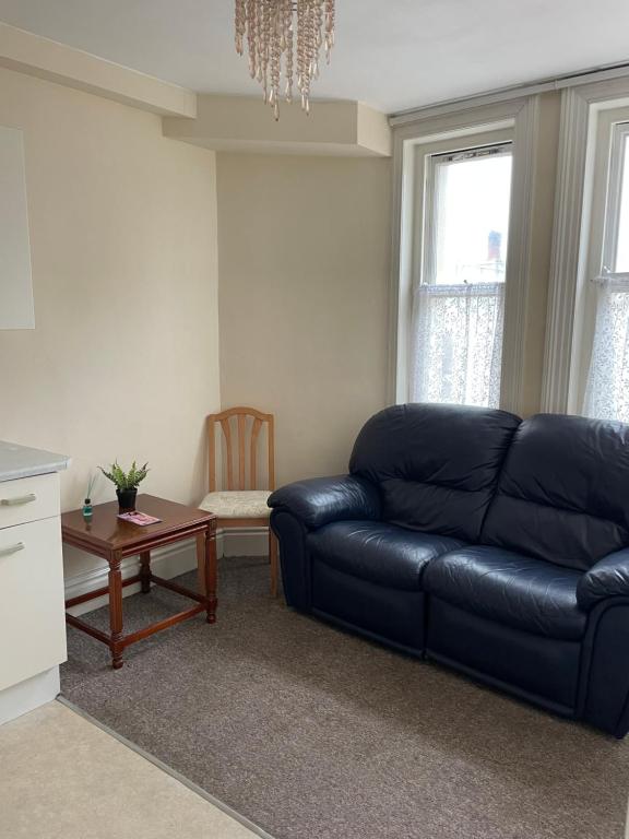 布莱顿霍夫Flat in Brighton city centre的客厅配有黑色真皮沙发和桌子